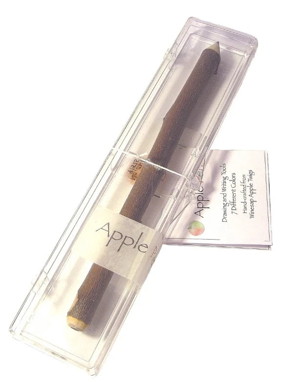 A wooden apple-shaped writing utensil or pencil wrapped in a clear plastic case with a paper label reading 'Apple,' plus a small printed card behind it on a white background.